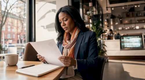 Woman reviewing compliance documents at desk